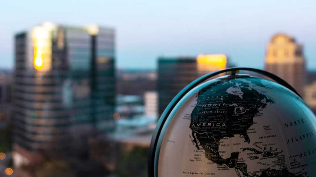 old-fashioned globe in foreground with blurred cityscape in background