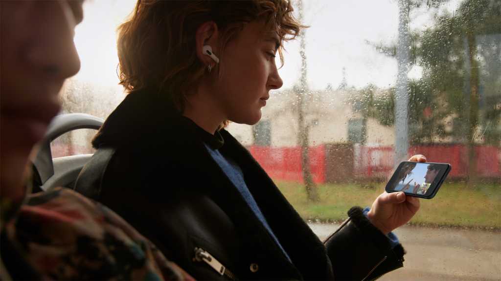 A woman uses an iPhone SE 3 in the rain