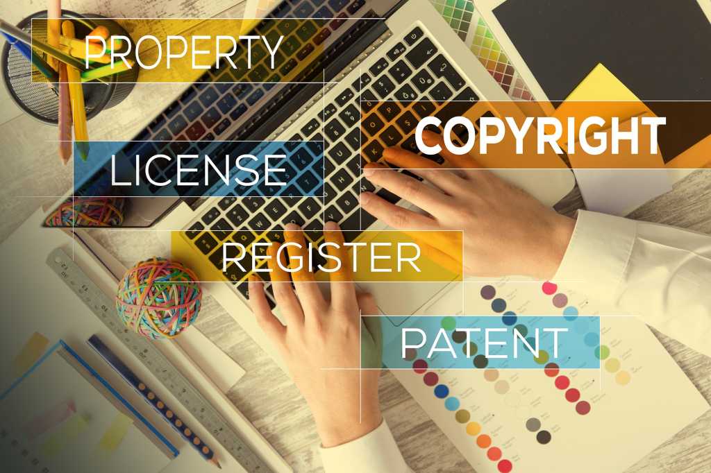 An overlay of intellectual property protections against a user's hands typing on a laptop.