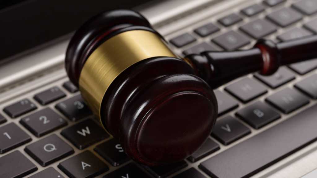 A photograph of a gavel lying sideways on a keyboard.